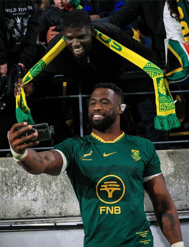 Siya Kolisi taking a selfie with supporters